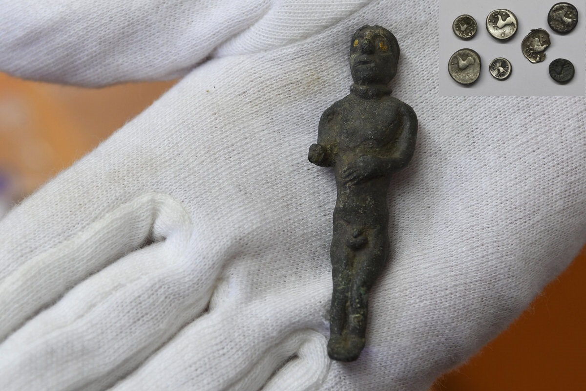 Small bronze statue with golden eyes from Janovce Slovakia lies on hand