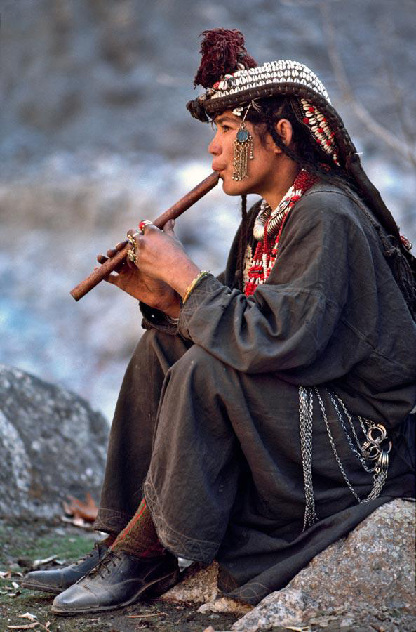 A Kalash woman playing on flute in Chitral